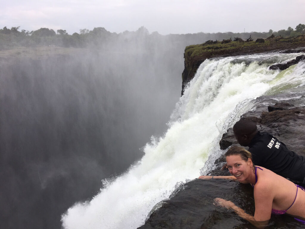 Renate ligt in Devil's pool op de rand waar het water naar beneden stort. Dit kan alleen bij laagwater.